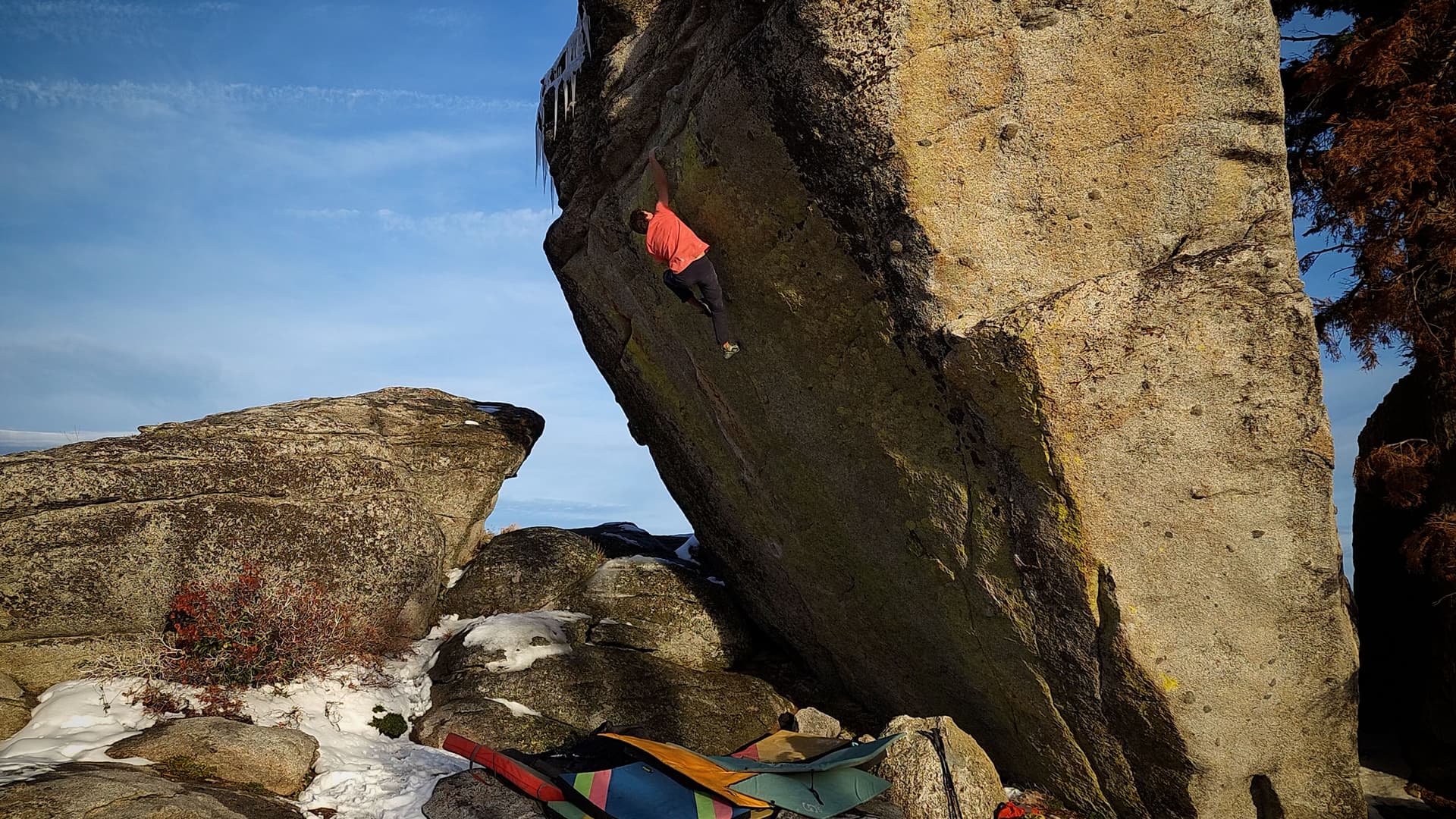 A man rock climbing a large boulder.